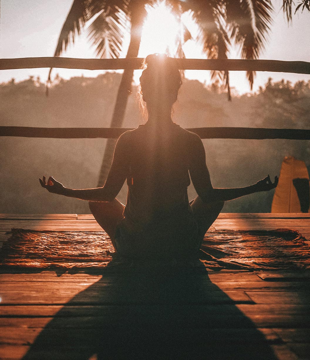 Persona meditando al amanecer durante una práctica de movimiento consciente