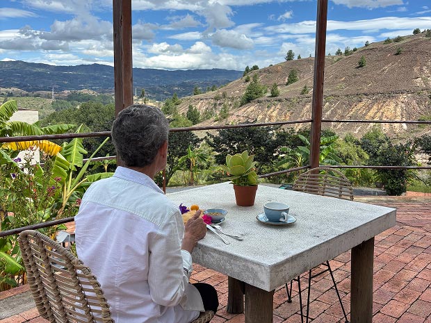 Persona contemplando el paisaje natural desde una terraza durante una estancia de silencio en Alma Loto