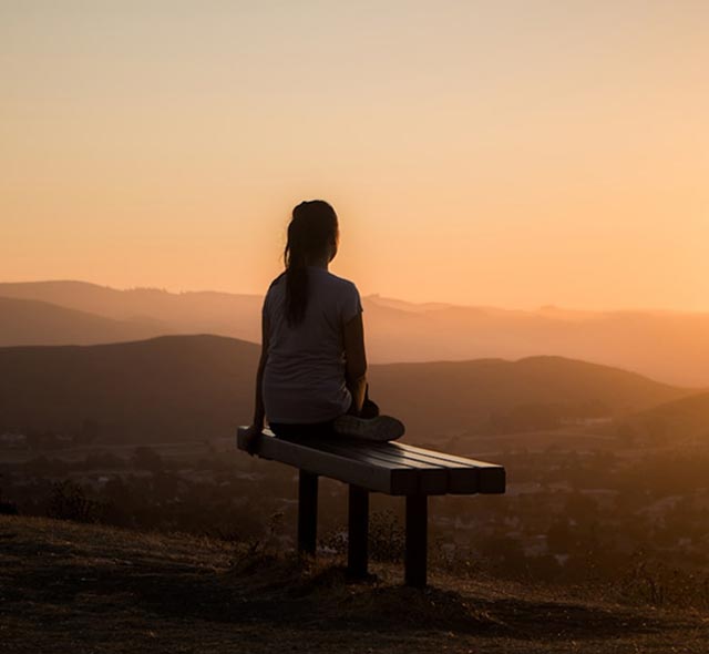Persona sentada en meditación al atardecer durante una práctica de Shamatha