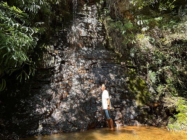 Persona contemplando una cascada natural durante un retiro de silencio en Alma Loto